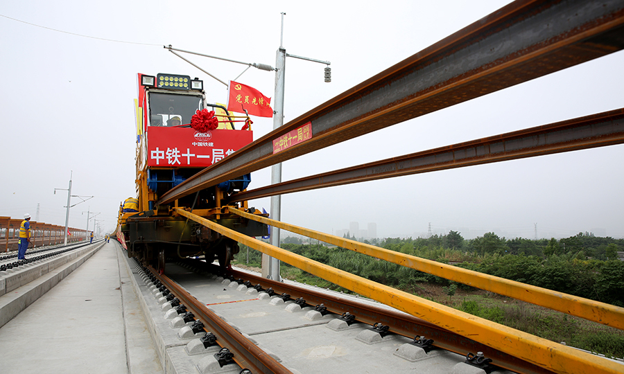 圖為作業(yè)人員操作鋪軌機(jī)進(jìn)行500米長(zhǎng)軌推送作業(yè)。（彭特 攝）