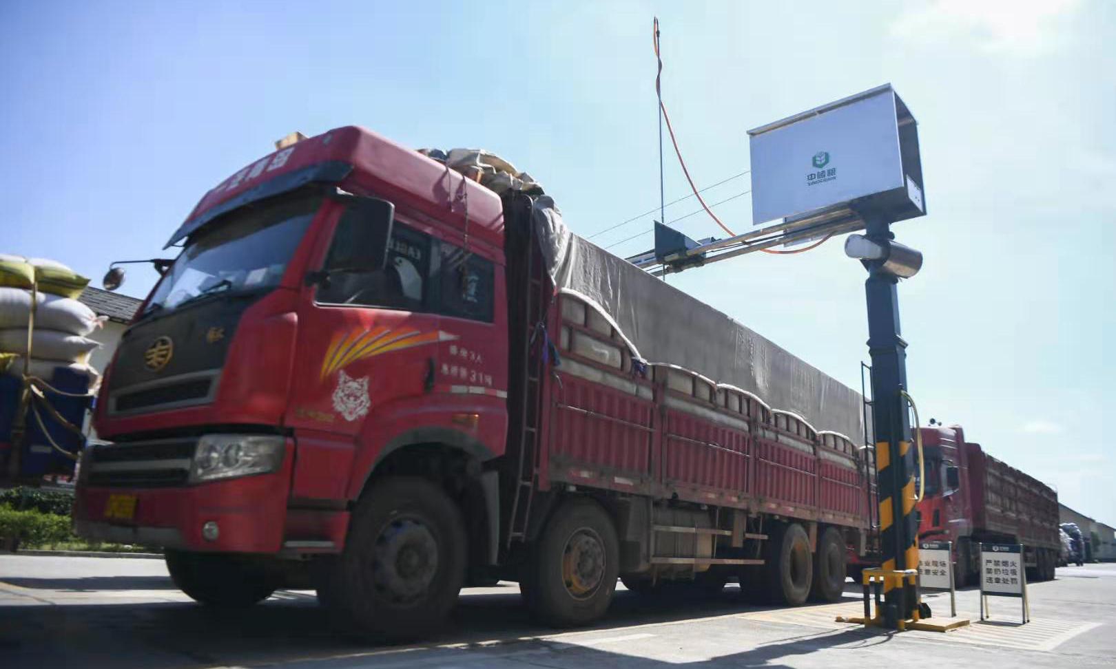 正值夏糧收購時節(jié)，記者來到位于湖南寧鄉(xiāng)的中央儲備糧寧鄉(xiāng)直屬庫進行探訪。為保證入庫糧食的質量，中儲糧寧鄉(xiāng)直屬庫應用機械對糧食進行扦樣檢測、確定糧食等級，只有達到國家標準三等及以上的才允許入庫。智能控溫、氮氣殺蟲、超清監(jiān)控等技術手段在倉庫中應用，確保了糧食在儲存過程中不會輕易發(fā)生蟲害和變質。隨著智能化、信息化水平不斷提高，科技在糧食存儲中的作用日益體現(xiàn)。圖為7月30日，裝滿糧食的卡車在中儲糧寧鄉(xiāng)直屬庫排隊等候扦樣。（新華社記者 薛宇舸 攝）