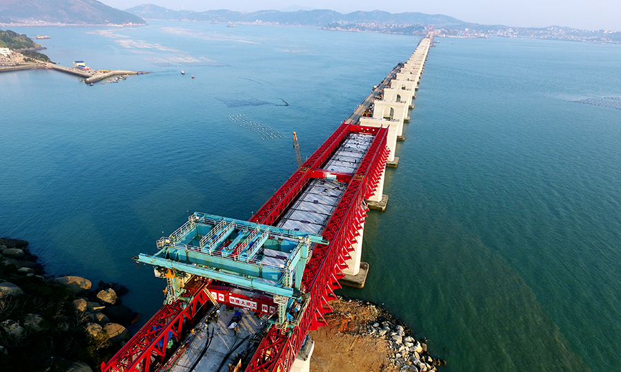 近日，由中國(guó)鐵建大橋局參建的福（州）平（潭）鐵路平潭海峽公鐵兩用大橋平潭段公路鐵路實(shí)現(xiàn)全部貫通，為后續(xù)架梁鋪軌創(chuàng)造了條件。圖為國(guó)內(nèi)首座臺(tái)風(fēng)區(qū)雙孔連做造橋機(jī)作業(yè)。