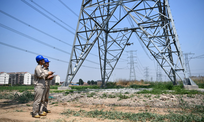 6月24日，天津氣象部門發(fā)布高溫橙色預(yù)警信號(hào)，部分地區(qū)最高氣溫超過(guò)37℃。國(guó)家電網(wǎng)天津檢修公司特高壓輸電運(yùn)檢室無(wú)人機(jī)巡檢班的電力工人依照“迎峰度夏特巡”要求，在魯固、錫泰、廊河三條特高壓輸電線路并行處開展無(wú)人機(jī)巡檢工作，確保輸電安全。圖為6月24日，電力工人操作無(wú)人機(jī)準(zhǔn)備開始巡檢工作。（新華社記者 李然 攝）