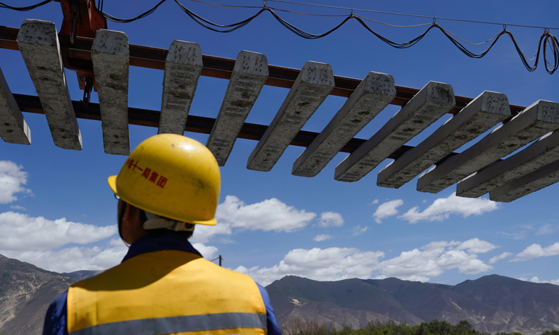 圖為6月6日，負(fù)責(zé)鋪軌的中鐵十一局集團(tuán)的建設(shè)者在現(xiàn)場(chǎng)作業(yè)。（新華社記者 普布扎西 攝）