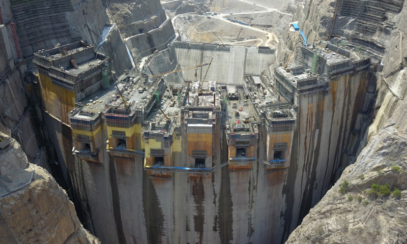 烏東德水電站位于四川省會東縣和云南省祿勸縣交界處金沙江河道上，水電站壩頂高程988米，最大壩高270米，總庫容74.08億立方米。電站安裝12臺單機容量85萬千瓦的水輪發電機組，裝機總容量1020萬千瓦，年發電量389.1億千瓦時。圖為5月30日，無人機拍攝建設中的烏東德水電站大壩主體工程。（新華社記者 陳曄華 攝）