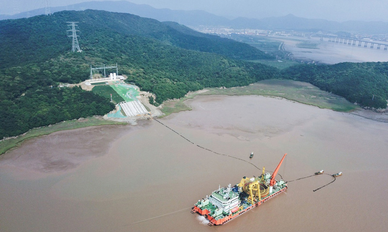 6月2日，舟山500千伏交聯(lián)聚乙烯海纜敷設(shè)工程順利完工。該工程分為兩回路，每回路敷設(shè)3根500千伏交聯(lián)聚乙烯海纜，從寧波市鎮(zhèn)海新泓口圍堤入海至舟山大鵬山島登陸，每條長16.8公里。500千伏交聯(lián)聚乙烯海纜在研發(fā)、實驗、檢測、制造上實現(xiàn)全程國產(chǎn)，促進了高端電纜國產(chǎn)化。圖為6月2日，最后一段海底電纜從海纜施工船上緩緩?fù)舷蛑凵酱簌i山島的終端站。（新華社記者 徐昱 攝）