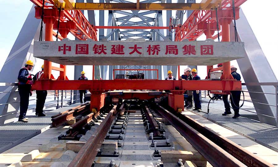 同江中俄鐵路大橋是中國首座跨境四線套軌板式無砟軌道鐵路大橋，可適應(yīng)中俄兩國不同規(guī)格的軌距。大橋無砟軌道板為四線套軌板式結(jié)構(gòu)，俄方軌距線路在左為1520mm，國內(nèi)軌距線路在右為1435mm，兩者相差85mm。該板型為國內(nèi)外首次采用。圖為中國鐵建大橋局四公司同江中俄鐵路大橋項(xiàng)目中俄交界最后144米鋪軌。