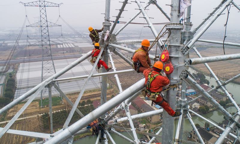 2月1日，在位于浙江省嘉興市嘉善縣的1000千伏皖電東送特高壓輸電工程改接現場，國家電網施工人員正在新建的高塔上加緊施工。（新華社記者 徐昱 攝）