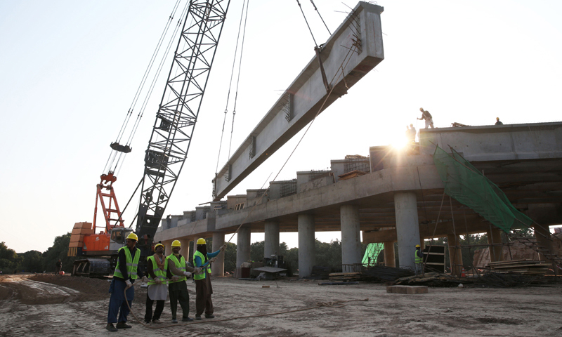 在巴基斯坦木爾坦附近的施工現場，幾名巴基斯坦工人配合吊車進行橋梁吊裝作業。（新華社記者 劉天 攝）