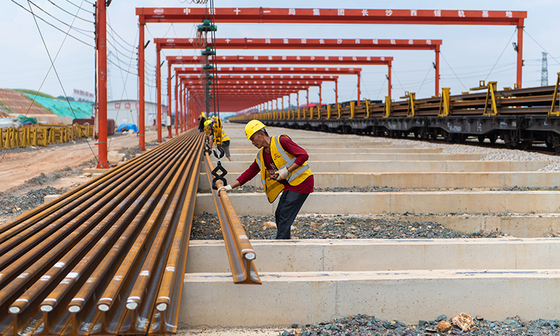 據了解，常益長鐵路線路全長約157公里，設計時速350公里，是國家“八縱八橫”高速鐵路網的重要組成部分。圖為在中鐵十一局常益長鐵路長沙西鋪軌基地，工作人員在卸載軌道。新華社記者 陳思汗 攝