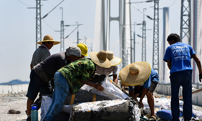 圖為9月15日拍攝的施工人員在廣州南沙港鐵路跨西江特大斜拉橋鋪軌現場作業。（新華社記者 劉大偉 攝）