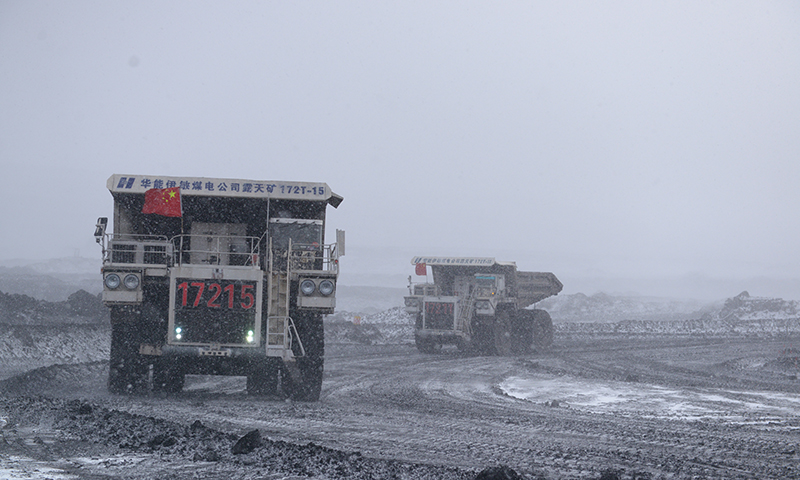 圖為華能伊敏露天礦自卸卡車風雪中保煤炭運輸。