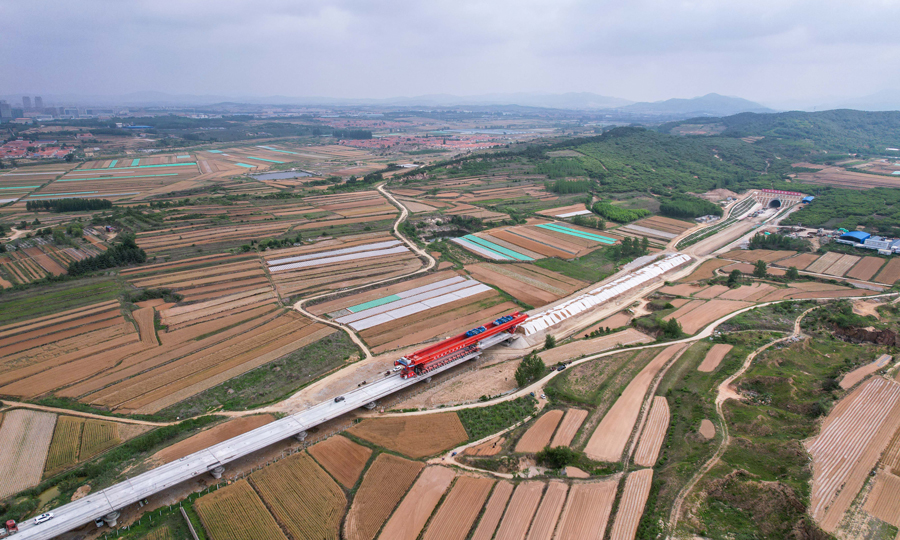 6月8日，隨著鋸河特大橋62號(hào)墩至63號(hào)墩的箱梁落定，中國(guó)中鐵旗下中鐵四局承建萊榮高鐵乳山段大里程方向306榀預(yù)制箱梁全部架設(shè)完成。該箱梁每榀長(zhǎng)32.6米、寬12.6米、高3米，重達(dá)790.3噸。圖為項(xiàng)目建設(shè)現(xiàn)場(chǎng)。