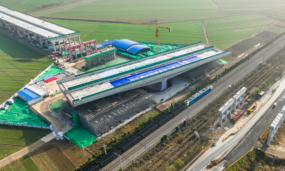 跨京滬鐵路轉(zhuǎn)體橋上部結(jié)構(gòu)采用預(yù)應(yīng)力混凝土T構(gòu)，跨徑組合為（68+68）米，下部結(jié)構(gòu)主墩采用“V”型空心墩設(shè)計(jì)，整幅橋梁全寬38.33米，轉(zhuǎn)體重量高達(dá)25680噸，主承臺(tái)深基坑開(kāi)挖處臨近繁忙干線(xiàn)京滬鐵路，距路基坡腳線(xiàn)最近處僅有15米，臨近鐵路基坑開(kāi)挖深度10余米，施工過(guò)程復(fù)雜、精度要求高。圖為轉(zhuǎn)體橋轉(zhuǎn)體中。