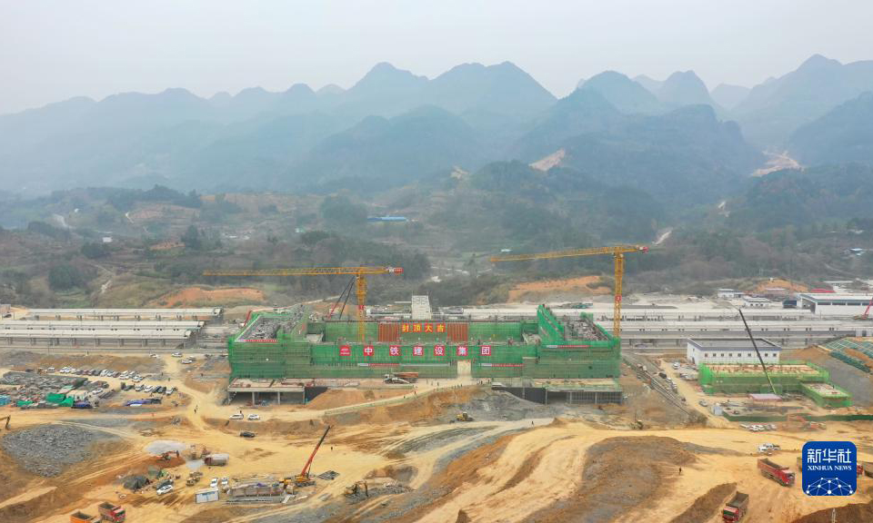 12月12日，隨著最后一方混凝土澆筑完成，由中鐵建設集團承建的貴南高鐵荔波站站房主體結構順利封頂。據了解，荔波站位于貴州省荔波縣朝陽鎮境內，距離著名世界自然遺產地小七孔景區僅約15公里，開通后將大大方便旅客前往游玩。貴南高鐵連接貴州貴陽和廣西南寧，是我國“八縱八橫”高速鐵路網包海通道的組成部分，設計時速350公里。圖為荔波站站房成功封頂（無人機照片）。新華社記者 劉續 攝