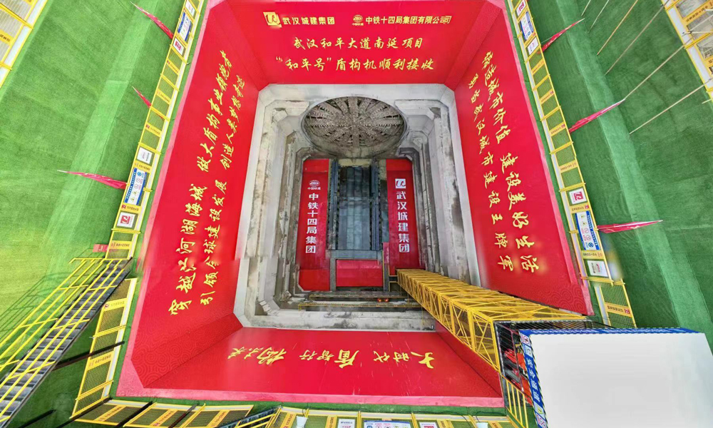 和平大道南延工程位于武漢市武昌區，北接和平大道、南連武金堤路，通過武昌古城、下穿蛇山，是貫通武昌順江通道的控制性工程。該工程全長3042米，其中1390米采用開挖直徑為16.03米的泥水平衡盾構機“和平號”施工。該隧道為國內最大直徑單管雙層盾構隧道，雙向6車道，設計時速50公里。圖為“和平號”盾構機出洞現場航拍。