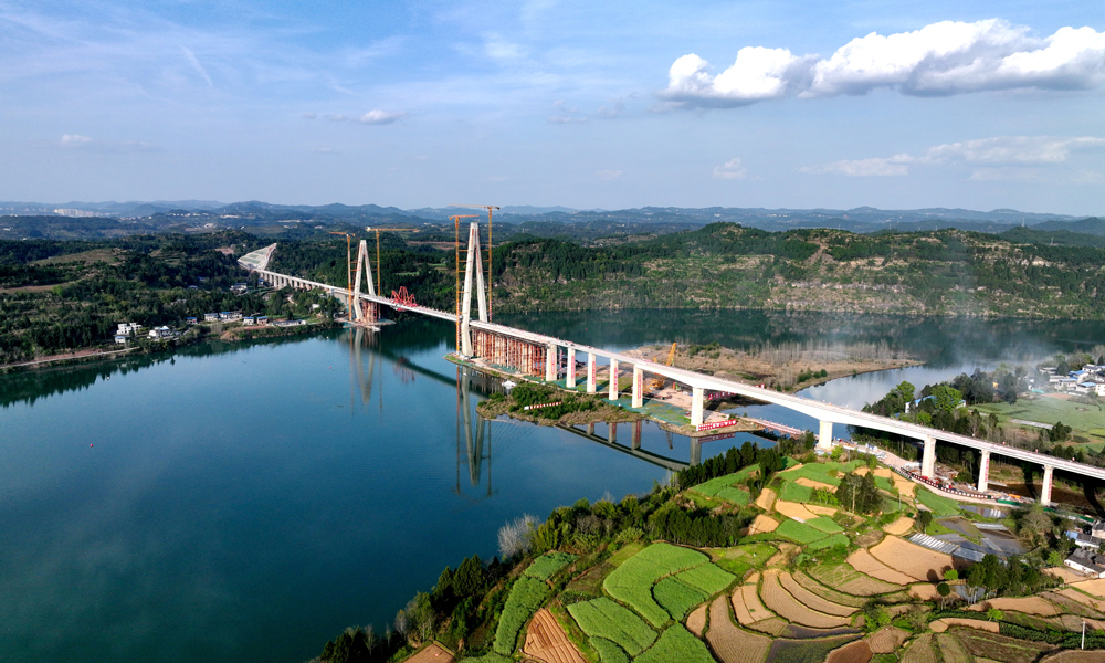 我國川東北地區一直以復雜不良地質、區域河流密集、環境敏感多變著稱，而漢巴南高鐵（南充—巴中段）沿線地形條件最為復雜，這也是四川省東北地區首次修建高標準高速鐵路。建設過程中，鐵五院充分發揮技術優勢，堅持“環保選線、地質選線”的設計理念，積極組織專題研究，大幅減少了工程對當地生態環境、基本農田的影響，保證了站型、橋隧結構與景區協調，其中南充—巴中段線路正線橋梁共計112座，橋梁累計長度逾43公里。圖為大橋航拍全景。