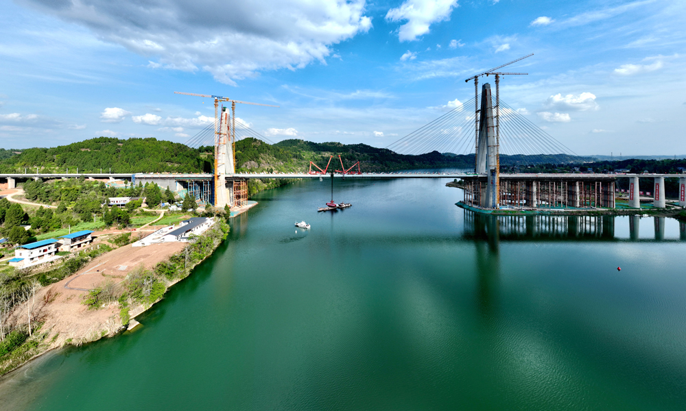 其中，嘉陵江特大橋全長1770.82米，大橋主跨335米，是目前我國在建跨度最大的雙線高速鐵路高低塔混合梁斜拉橋，橋塔呈“鉆石型”結構，雙塔高分別為164.5米和120米，分別通過64根、44根高強平行鋼絲斜拉索，共同支撐起大橋主梁。圖為大橋航拍側景。