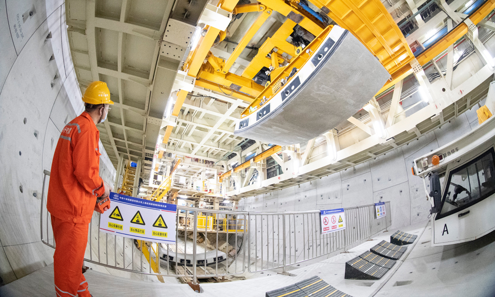 據(jù)介紹，上海機(jī)場(chǎng)聯(lián)絡(luò)線在國(guó)內(nèi)首次采用全預(yù)制裝配結(jié)構(gòu)體系，開(kāi)創(chuàng)了類似施工工藝先河。面對(duì)預(yù)制構(gòu)件體量大、單構(gòu)件尺寸大、安裝節(jié)點(diǎn)精度要求高、拼裝難度大等要求，項(xiàng)目團(tuán)隊(duì)成立工匠工作室，圍繞全預(yù)制拼裝開(kāi)展課題研究，在國(guó)內(nèi)首次研發(fā)弧形件精調(diào)裝置，將拼裝精度控制在1毫米以內(nèi)；在國(guó)內(nèi)首次研發(fā)應(yīng)用中隔墻拼裝設(shè)備，實(shí)現(xiàn)中隔墻的自動(dòng)抓取到精度控制的智能一鍵式拼裝，單月最高拼裝達(dá)到1200米，創(chuàng)造了全線最快拼裝記錄。圖為施工人員正在進(jìn)行隧道管片吊裝。