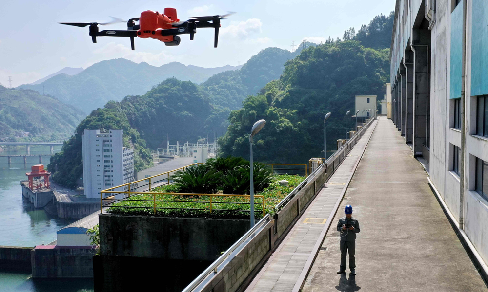 近日，國家電網湖南水電公司員工操作無人機巡查柘溪電廠水工建筑物，確保汛期設備安全。