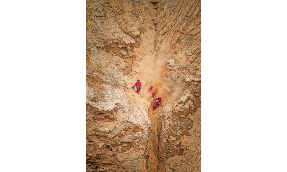 獅新58井區三維項目是青海油田增儲上產的重要區塊，項目工區海拔2850—3697米，山地占比78%。青海物探處整合優勢資源，集中力量，投入外接式節點采集設備9萬道，山地鉆機100臺，運載設備250臺（套），施工人員2500余人。圖為物探隊員在柴達木盆地英雄嶺地區高原山地進行測量作業。呂殿杰 攝