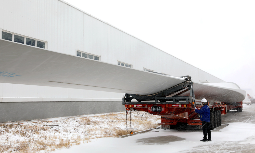 在內(nèi)蒙古自治區(qū)東方電氣興安盟風(fēng)電基地，吉林前郭20萬千瓦風(fēng)電項(xiàng)目的風(fēng)機(jī)葉片正整裝待發(fā)。東方電氣集團(tuán)風(fēng)機(jī)制造項(xiàng)目團(tuán)隊(duì)頂著風(fēng)雪，仔細(xì)檢查風(fēng)機(jī)葉片裝車預(yù)緊部位，確保安全穩(wěn)妥運(yùn)往風(fēng)場(chǎng)。