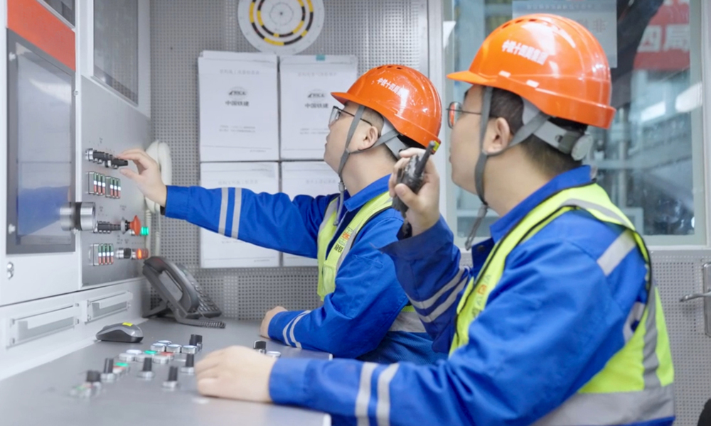 穗莞深城際機前段工程位于粵港澳大灣區(qū)廣深港城鎮(zhèn)發(fā)展帶與深圳市西部發(fā)展帶內，是大灣區(qū)城際鐵路網(wǎng)廣深主軸的重要組成部分，建成通車后將進一步提升穗莞深城際鐵路功能，對完善粵港澳大灣區(qū)城際網(wǎng)絡，實現(xiàn)區(qū)域經(jīng)濟一體化發(fā)展具有重要意義。圖為技術人員在盾構機駕駛室里操作盾構機。