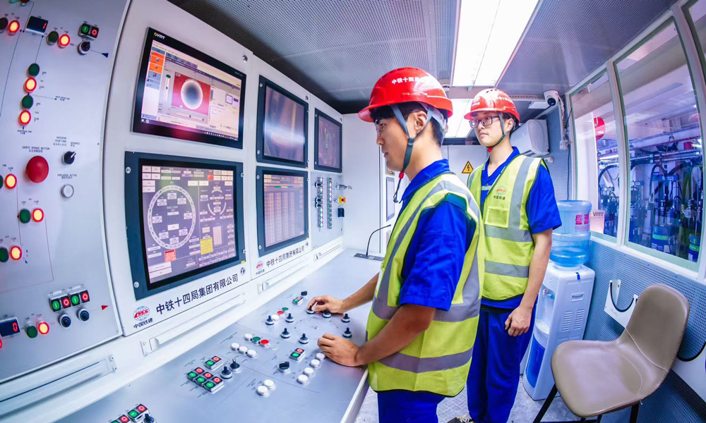 針對施工重難點，中鐵十四局結合深耕黃河流域盾構施工經驗，量身打造“山河號”盾構機，配備了配備帶壓復合型刀盤、伸縮式主驅動等先進技術，并搭載了超前地質預報、地層界面識別等智能化裝備系統，盾構機總裝達到世界先進水平。圖為駕駛艙內，技術人員操作盾構機向前掘進。