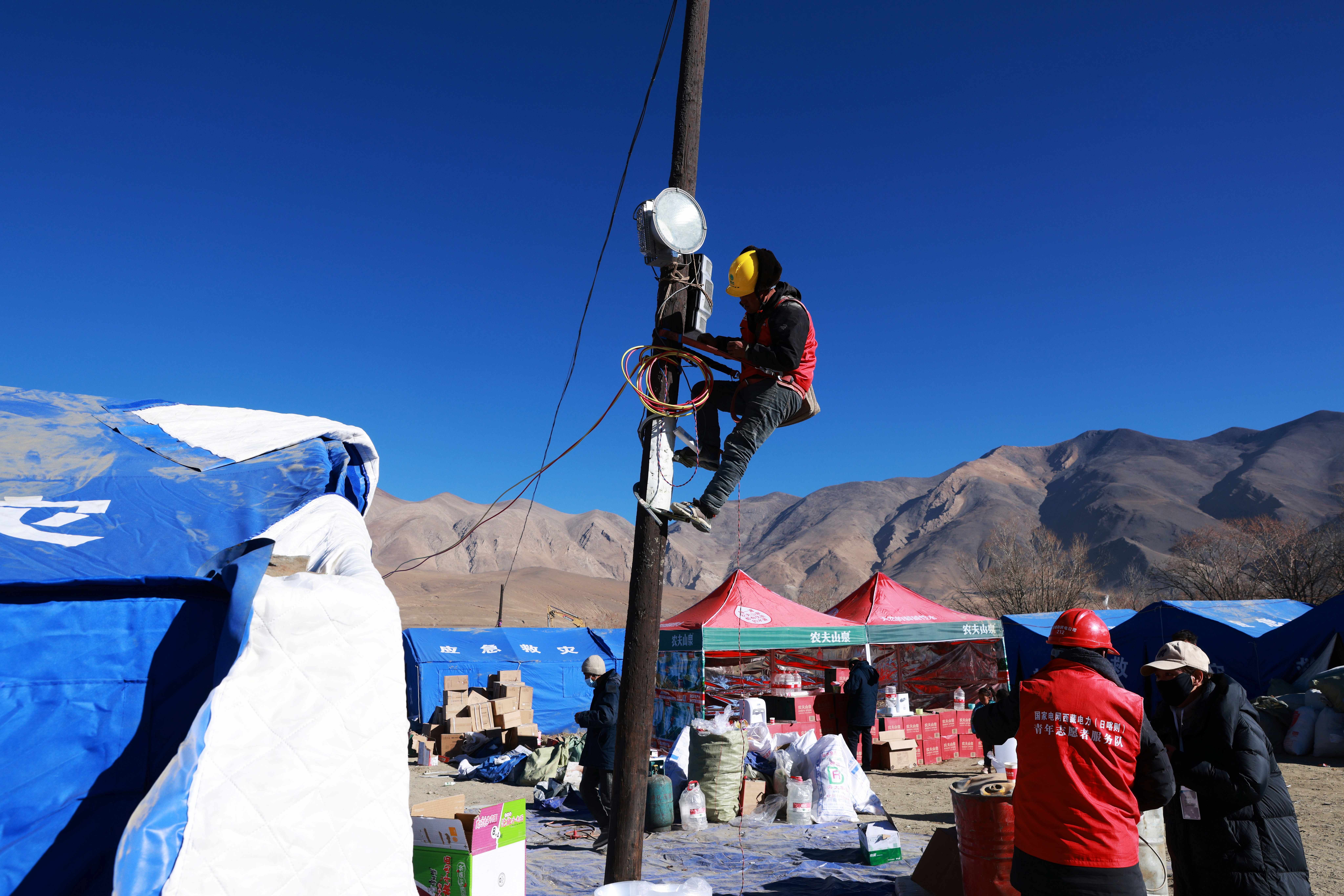 國網西藏電力救災隊伍為定日縣長所鄉通來村居民安置點安裝照明燈。