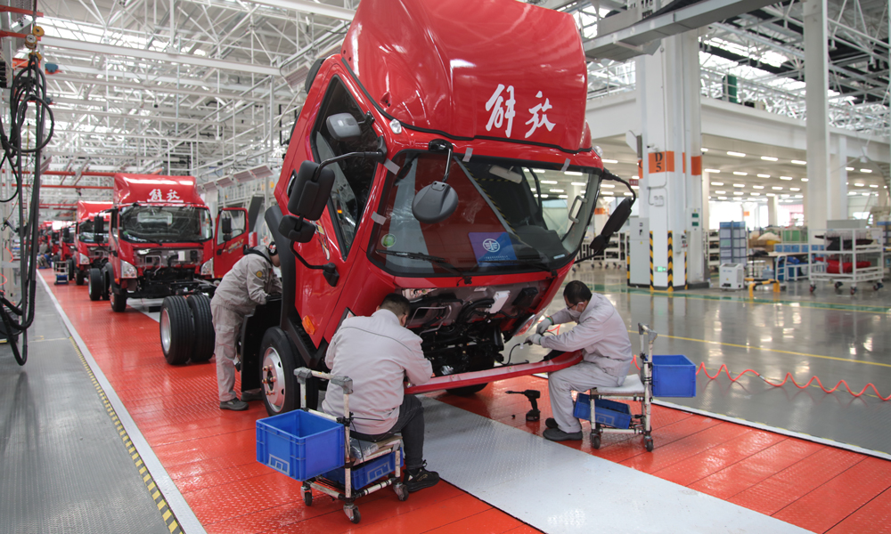 工作人員在位于山東省青島市的一汽解放青汽公司總裝配二車間裝配解放輕卡產(chǎn)品。