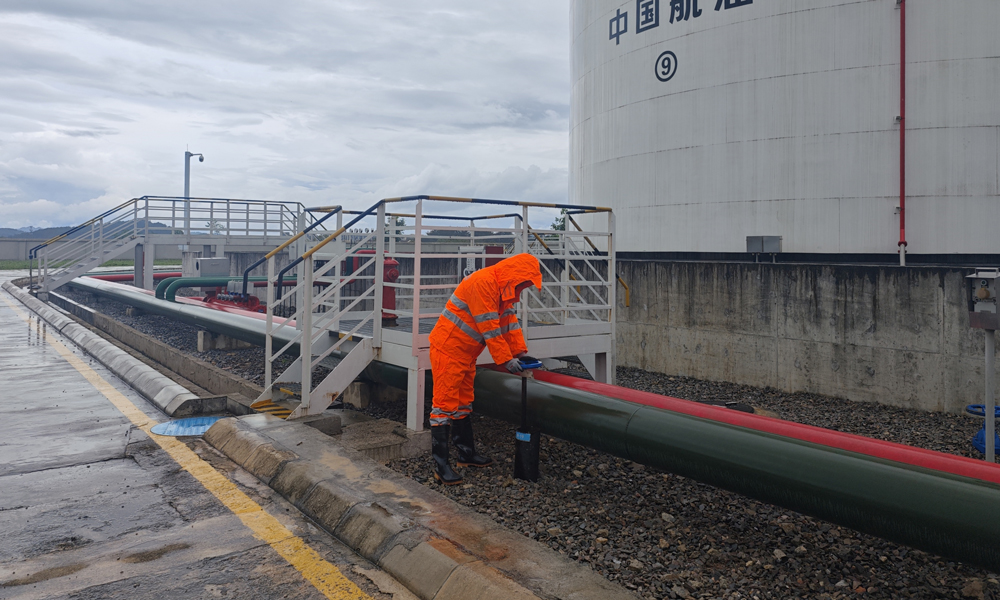 中國(guó)航油貴州分公司業(yè)務(wù)油庫(kù)值班人員在暴雨天巡查儲(chǔ)油罐區(qū)。