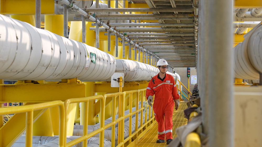 海上生產(chǎn)人員穿過平臺間棧橋進(jìn)行設(shè)備巡檢。