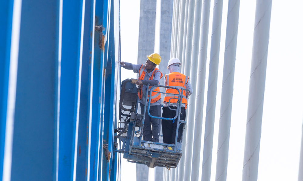 圖為施工人員進(jìn)行鋼桁梁焊縫檢測(cè)。