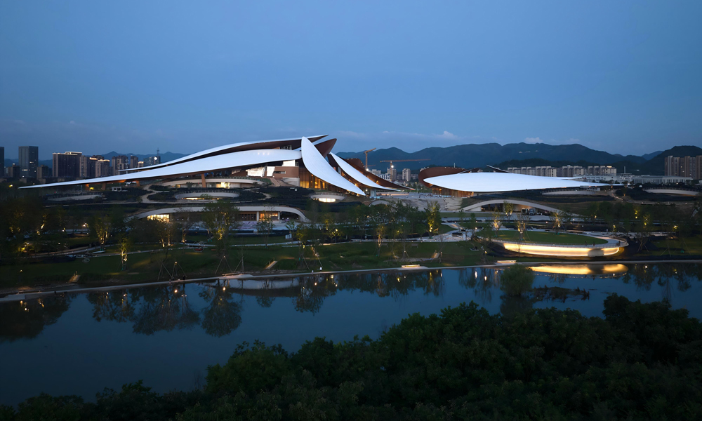 安吉文化藝術中心項目整體設計以“竹葉茶田”為靈感源泉，匠心打造集文化、藝術、休閑于一體的城市綜合性地標。十二片靈動竹葉仿佛漂浮于山水之間，形態各異的葉片層疊錯落，與幕墻、結構、建筑空間交接關系復雜，它們或舒或卷，將鋼筋鐵骨定格為大地的詩行，以建筑語言重新詮釋竹海文化與江浙氣韻。