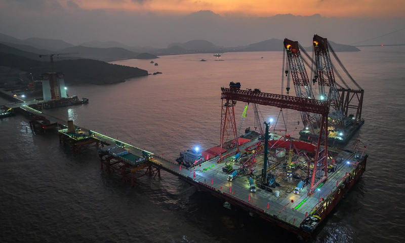 1月7日清晨，甬舟鐵路西堠門公鐵兩用大橋5號主墩超大直徑鉆孔樁灌注施工現(xiàn)場，工人在澆筑最后一根鉆孔樁（無人機(jī)照片）。新華社發(fā)（姚峰?攝）