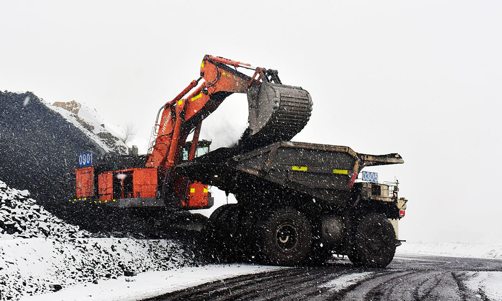 準(zhǔn)能集團(tuán)哈爾烏素露天煤礦在降雪天氣前加大場地存煤，最大限度減少天氣對上煤工作的影響，確保原煤生產(chǎn)的穩(wěn)定接續(xù)。圖為液壓反鏟在降雪天氣為卡車裝煤。