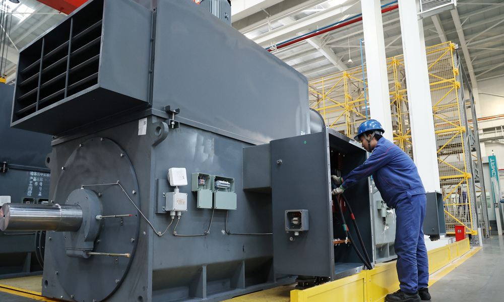 哈電集團佳電股份高壓電機數字化裝配車間現場，操作者在加工精細化工及原料工程項目，產品順利交付將助力我國石化產業向高端產業延伸，加快推動石化產業轉型升級。