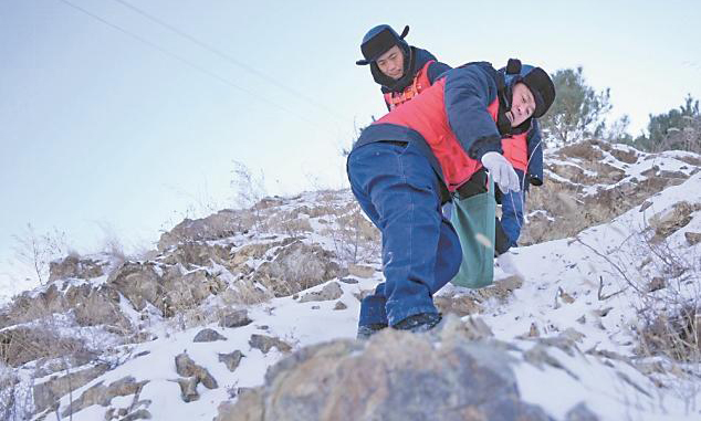 國家電網(wǎng)蒙東通遼奈曼旗供電公司工作人員巡檢10千伏青龍山線后相互攙扶下山。