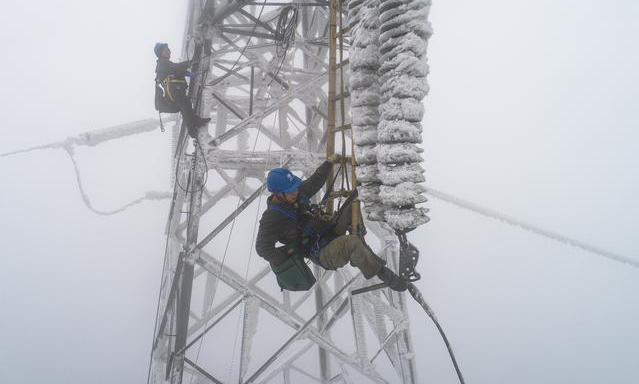 2月12日，受雨雪冰凍天氣影響，國網湖北省電力公司一供電線路出現故障，導致京廣高鐵橫店東至孝感北區段供電能力不足，造成途經該區段旅客列車不同程度晚點。故障發生后，國網武漢供電公司組織人員全力進行搶修。圖為搶修現場。（新華社記者 肖藝九 攝）