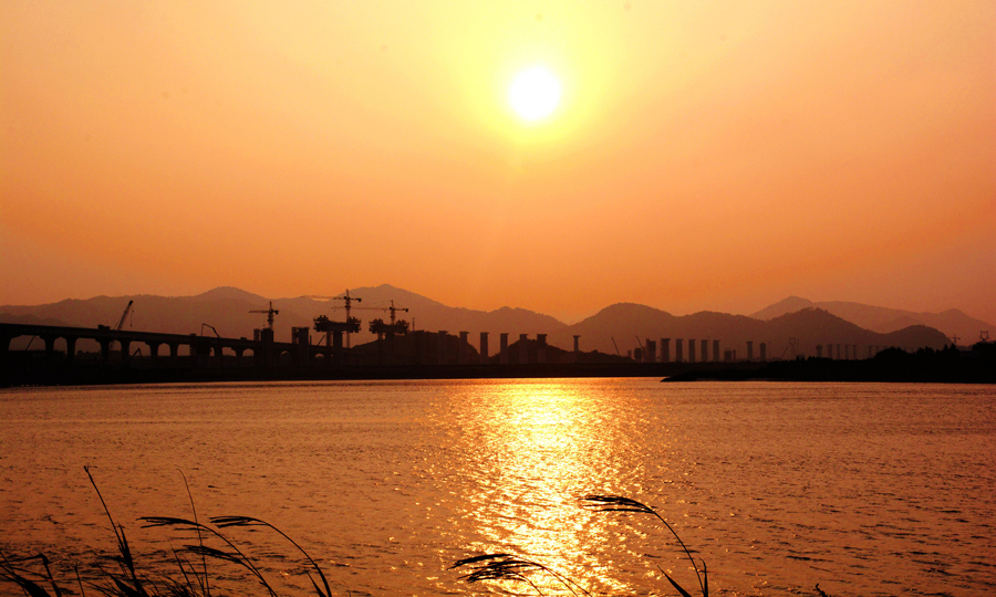 據(jù)悉，金臺鐵路是浙江省“大通道建設(shè)”的重點項目，是浙江省主導(dǎo)建設(shè)的第一條電氣化鐵路，對暢通浙江沿海及金臺沿線與浙中地區(qū)、皖贛及中西部地區(qū)的貨運交流、促進沿線社會經(jīng)濟發(fā)展具有重要意義。金臺鐵路建成后，還將徹底結(jié)束浙江省仙居、磐安等縣無鐵路的歷史。圖為黃昏下的靈江特大橋。