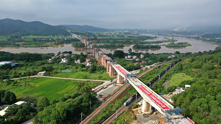 嶺南晨曦里，兩片巨型梁體在千斤頂的拉動下開始逆時針旋轉，在施工過程中，中鐵二十五局技術人員布置轉體裝置，實時動態監控動力系統運行情況、轉盤轉過的刻度，每轉5度報告轉體進度、應力變化等情況。圖為橋梁完成轉體精準對接。（陳浩 攝）