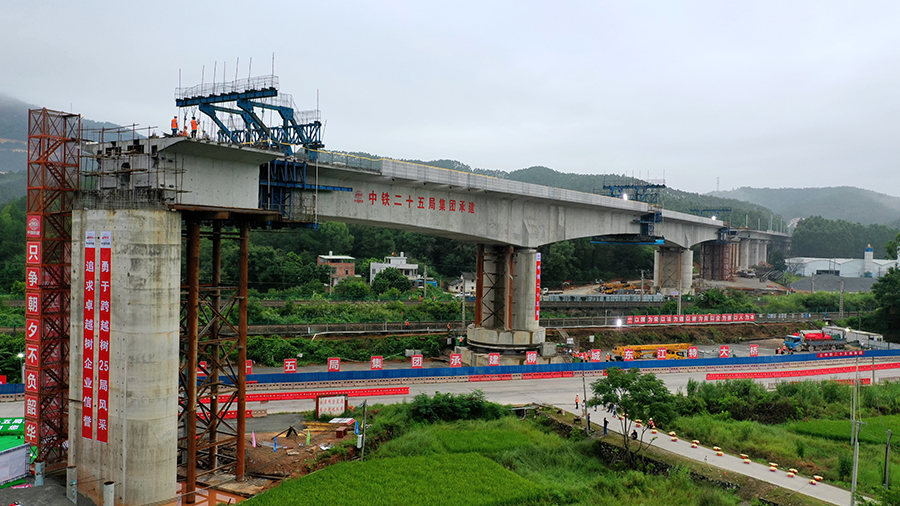 為了減少對鐵路運營的影響，橋梁采用轉體施工方法，先平行于鐵路線兩側修建橋墩及梁體，再利用自動連續頂推轉體系統使橋體逆時針旋轉，最后實現梁體對接，與京九鐵路形成37°夾角。轉體過程中保證橋體的平衡是關鍵，項目部通過轉體稱重、配重等技術手段，使結構體重心回到橋墩中心，確保轉體過程中安全順利。圖為轉體施工進行中。（陳浩 攝）