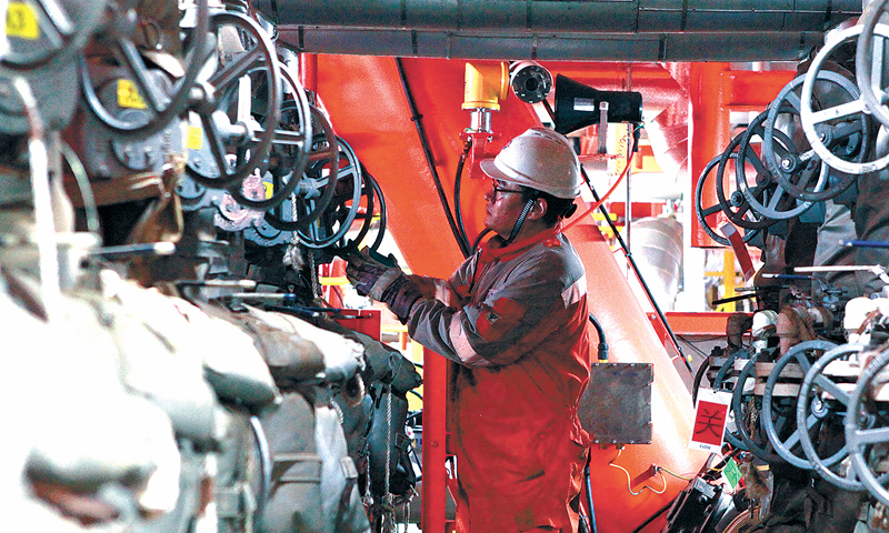 秦斌所在的中國海油旅大21-2油田包括通過冷采開發(fā)的A平臺(tái)和通過熱采開發(fā)的B平臺(tái)，自海上“安家落戶”后，兩個(gè)平臺(tái)便合二為一。整個(gè)平臺(tái)面積不大，分量卻不輕，B平臺(tái)作為我國首個(gè)規(guī)模化熱采技術(shù)集成示范平臺(tái)，肩負(fù)著單項(xiàng)熱采技術(shù)優(yōu)化、系統(tǒng)熱采技術(shù)集成創(chuàng)新應(yīng)用、熱采新技術(shù)試驗(yàn)等示范性任務(wù)，對(duì)于渤海油田上產(chǎn)4000萬噸，保障國家能源安全都具有重要意義。圖為井口崗員工正在操作油井管匯閥門，準(zhǔn)備對(duì)油井進(jìn)行計(jì)量。