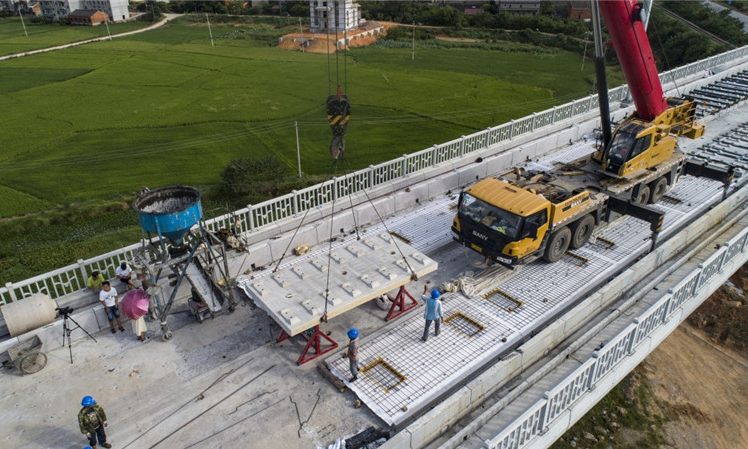 昌贛高鐵是京九高鐵的重要組成部分，總長約415.2公里，設(shè)計(jì)行車速度為350公里/小時(shí)。圖為8月30日，中鐵十一局職工在江西省豐城市境內(nèi)的昌贛高鐵孫渡特大橋上吊裝無砟軌道板。（新華社記者 杜華舉 攝）