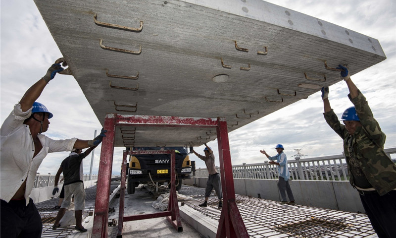 圖為8月30日，中鐵十一局職工在江西省豐城市境內(nèi)的昌贛高鐵孫渡特大橋上吊裝無砟軌道板。（新華社記者 杜華舉 攝）