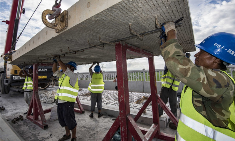 圖為8月30日，中鐵十一局職工在江西省豐城市境內(nèi)的昌贛高鐵孫渡特大橋上吊裝無砟軌道板。（新華社記者 杜華舉 攝）