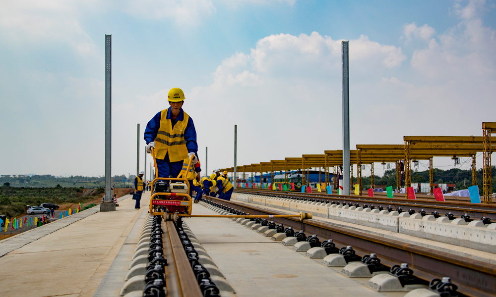 昌贛高鐵通車后，南昌至贛州的最快鐵路旅行時(shí)間將由現(xiàn)在的5小時(shí)縮短至2小時(shí)內(nèi)，京九通道客貨運(yùn)輸能力將得到大幅提升，對(duì)改善區(qū)域交通運(yùn)輸條件，加快沿線地區(qū)旅游、礦產(chǎn)資源開發(fā)，承接沿海發(fā)達(dá)地區(qū)產(chǎn)業(yè)轉(zhuǎn)移，密切東南沿海與中部地區(qū)的經(jīng)濟(jì)交流，促進(jìn)經(jīng)濟(jì)社會(huì)又快又好發(fā)展具有積極意義。圖為9月29日，中鐵十一局建設(shè)者在昌贛高鐵樟樹東鋪軌基地進(jìn)行500米長軌鋪設(shè)作業(yè)。